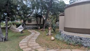 a garden with a hammock and a house with trees at Vgp Golden Beach Resort in Chennai