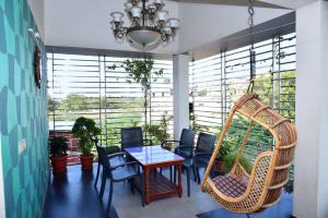a room with a table and chairs and a swing at Mango Tree Homestay in Hampi
