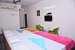 a bedroom with a large bed with green chairs at Mango Tree Homestay in Hampi