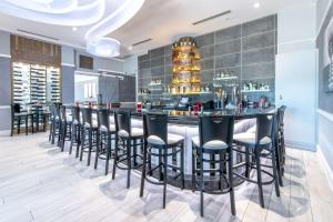a bar in a restaurant with black bar stools at Wyvern Hotel, Ascend Hotel Collection in Punta Gorda