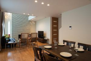a dining room and living room with a table and chairs at North Star Hirafu in Niseko