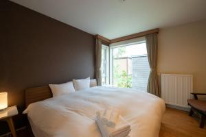 a bedroom with a bed with two towels on it at North Star Hirafu in Niseko