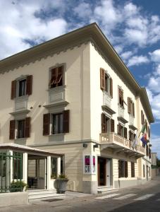 ein großes weißes Gebäude mit Fenstern und einem Balkon in der Unterkunft Residenza Mordini in La Maddalena