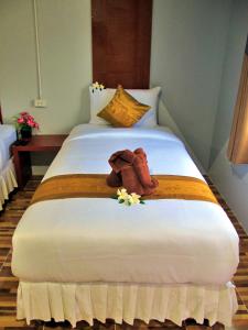 a bed with a towel and flowers on it at Chawlay Resort Koh Lipe in Ko Lipe