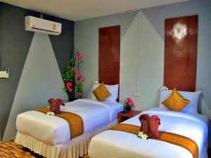 two beds in a hotel room with a christmas tree at Chawlay Resort Koh Lipe in Ko Lipe