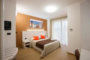 ein Schlafzimmer mit einem Bett mit zwei orangefarbenen Kissen in der Unterkunft La Casa del Turista in Gallipoli