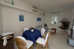 a living room with a blue table and chairs at FIDES ON THE LAKE in Marone