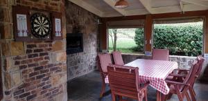 a dining room with a table and chairs and a dartboard at Alm-Ü in Dullstroom