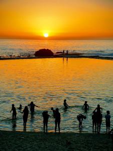 a group of people on the beach at sunset at Camps Bay Villa in Cape Town