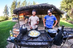 twee mannen naast een tafel met een grill bij Felix Unite Provenance Camp in Noordoewer