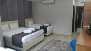 a hotel room with two beds and a couch at Grand Dost Hotel in Osmancık