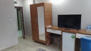 een kamer met een televisie en een bureau met een televisie bij Grand Dost Hotel in Osmancık