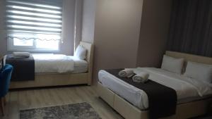 um quarto com 2 camas e uma janela em Grand Dost Hotel em Osmancık