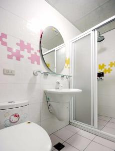 ein Badezimmer mit einem WC, einem Waschbecken und einem Spiegel in der Unterkunft Summer House in Altstadt von Hengchun