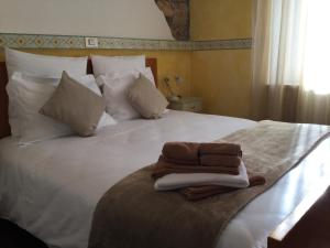 a white bed with a pile of towels on it at Albergo Ristorante Leso in Bosco Chiesanuova