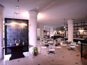 un restaurante con mesas y sillas en una habitación en Bella Vista Express Hotel, en Pantai Cenang