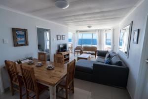 a living room with a table and a couch at Nothing But View in Hermanus