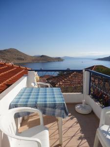 una mesa y sillas en un balcón con vistas al océano en Villa Yorgos, en Halki