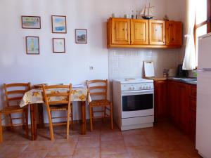cocina con mesa y horno de fogón blanco en Villa Yorgos, en Halki
