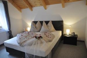 - une chambre dotée d'un grand lit avec des draps et des oreillers blancs dans l'établissement Ferienhaus Manuela, à Velden am Wörther See