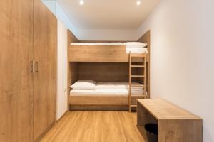 オエッツにあるApartment Waldesruhの二段ベッドとデスクが備わる小さな客室です。