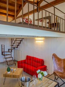 a living room with a red couch and a loft at Le Maestranze Deluxe Rooms in Sciacca