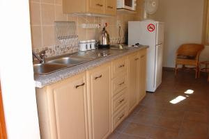 a kitchen with a sink and a refrigerator at Hibberdene Hideout in Hibberdene
