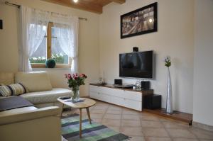 a living room with a couch and a tv at Ferienhaus Manuela in Velden am Wörthersee