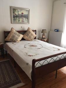 1 dormitorio con 1 cama grande con sábanas y almohadas blancas en 30 Amynta, en Katerini
