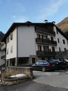 un edificio blanco con coches estacionados frente a él en Monolocale Energy en Carona