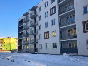an apartment building with snow in front of it at Apartament Studio 208 in Biała Podlaska