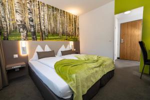 a bedroom with a large bed with a green blanket at Hotel Waldhorn in Bern