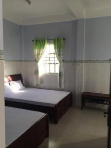 a bedroom with two beds and a window at Minh Duc Guesthouse in Phan Thiet