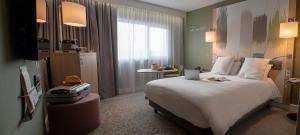 a hotel room with a bed and a television at Mercure Reims Parc Des Expositions in Reims +95 photos