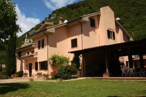 ein großes Haus mit einem Berg im Hintergrund in der Unterkunft Locanda Salimbeni in San Severino Marche