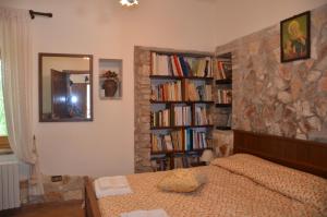 ein Schlafzimmer mit einem Bett und einem Bücherregal mit Büchern in der Unterkunft B&B La Terrazza Del Subasio in Assisi