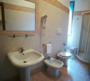 uma casa de banho com um lavatório, um WC e um espelho. em Hotel Universo em Fiuggi