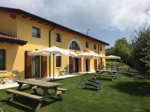 a group of picnic tables and umbrellas next to a building at Al Vajo Dependance - Apartments-Zimmer in Lazise