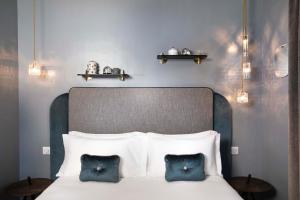 a bedroom with a bed with two blue pillows at Hôtel Eiffel Saint Charles in Paris +62 photos