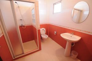 a bathroom with a toilet and a sink and a shower at Paradise Inn and Dining in Sara Buri