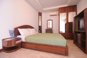 a bedroom with a bed and a tv in it at Paradise Inn and Dining in Sara Buri