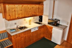 a small kitchen with wooden cabinets and a sink at Josef und Alexandra Ganner in Obertilliach