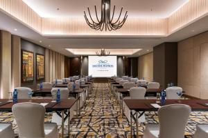 卢萨卡Neelkanth Sarovar Premiere的配有桌椅和投影屏幕的会议室 更多37张照片