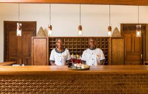 two chefs standing behind a bar in a restaurant at Sandies Baobab Beach Zanzibar in Nungwi
