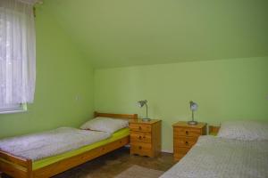 a bedroom with two beds and a window and two lamps at Agroturystyka na Kaszubach in Lipnica