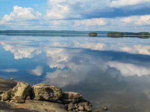 Holiday Home Huljakka by Interhome في Lipinlahti: اطلالة على بحيرة فيها سحب في الماء