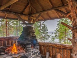 a fire pit in a cabin with a view of the ocean at Holiday Home Huljakka by Interhome in Lipinlahti +19 photos
