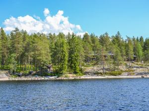 Holiday Home Huljakka by Interhome في Lipinlahti: اطلاله على شاطئ بحيره فيها اشجار