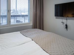 a white bed in a bedroom with a window at Holiday Home Tahko spa red - vuori apartment by Interhome in Tahkovuori