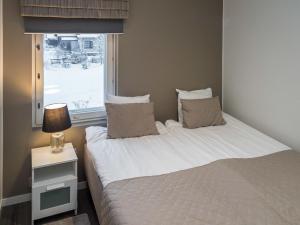 a small bedroom with a bed and a window at Holiday Home Tahko spa red - vuori apartment by Interhome in Tahkovuori +7 photos
